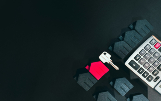 miniature houses, a house key, and a calculator on a dark background, representing florida real estate tax planning