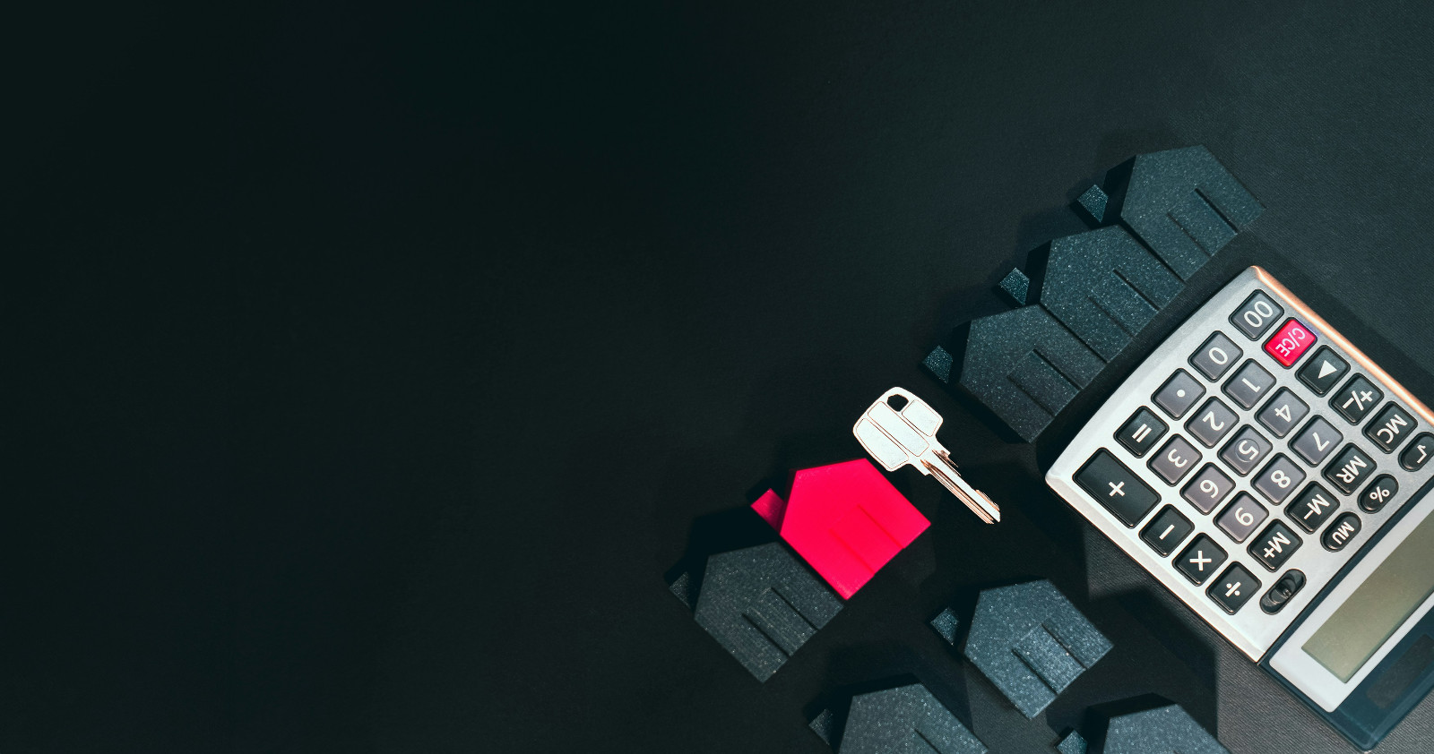 miniature houses, a house key, and a calculator on a dark background, representing florida real estate tax planning