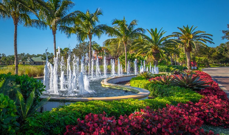 Fountain and palm tree landscaping at the Quail West entrance in Naples, Florida