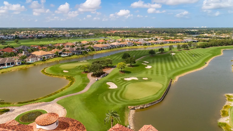 Aerial view of a Talis Park neighborhood with homes bordering the golf course and lake